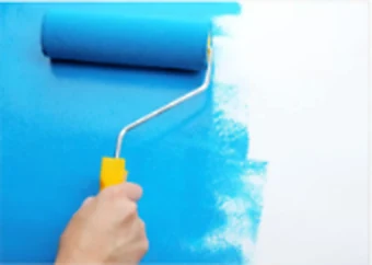 Rolo aplicando tinta azul em uma parede